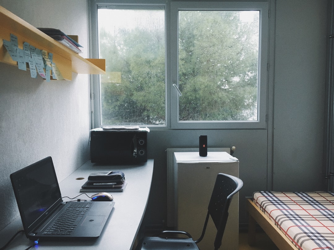 Student residence room with a study desk, bed and window